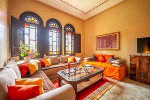 a living room with a couch and a table at Al Fassia Aguedal in Marrakech