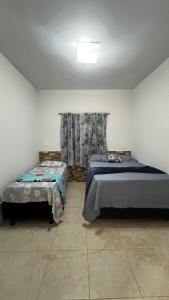 ein Schlafzimmer mit zwei Einzelbetten und einem Fenster in der Unterkunft Casa design Piri no centro de Pirenópolis in Pirenópolis + 37 Fotos