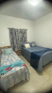a bedroom with two beds and a window at Casa design Piri no centro de Pirenópolis in Pirenópolis +45 photos