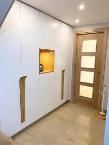 Habitación con armarios blancos y puerta. en Acogedor apartamento con acabados primera calidad, en Zaragoza