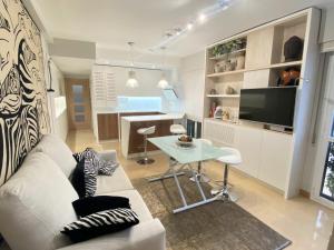 Una sala de estar con un sofá blanco y una mesa. en Acogedor apartamento con acabados primera calidad, en Zaragoza