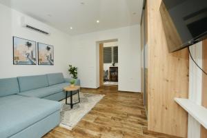 Una sala de estar con un sofá azul y una mesa. en Amantis, en Zadar