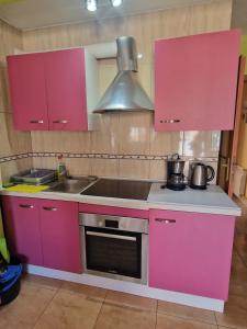 a kitchen with pink cabinets and a sink at Apartamento Riells in L'Escala