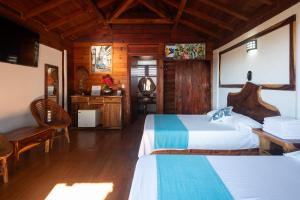a bedroom with two beds and a table and chairs at Casa Paraiso Hotel Boutique in Puerto Escondido +90 photos