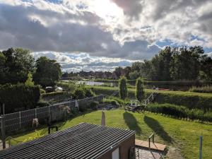 a view of a yard with a fence and a field at Emden - Ferienwohnung mit Kanal-Blick in Emden