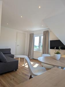 a living room with a couch and a table at Emden - Ferienwohnung mit Kanal-Blick in Emden