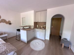 阿尔高内的伊门施塔特Alpenglück的房间里有白色橱柜和桌子的厨房 更多5张照片