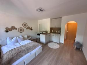 a bedroom with a white bed and a kitchen at Alpenglück in Immenstadt im Allgäu