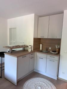 阿尔高内的伊门施塔特Alpenglück的厨房配有白色橱柜和带酒杯的吧台