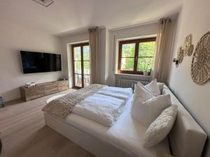 a bedroom with a bed and a flat screen tv at Alpenglück in Immenstadt im Allgäu