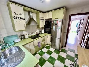 a kitchen with a green and white checkered floor at Casa SOL y MAR junto a la PLAYA in Sanlúcar de Barrameda