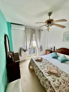 una camera da letto con un letto e un ventilatore a soffitto di Casa SOL y MAR junto a la PLAYA a Sanlúcar de Barrameda