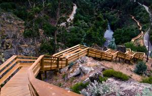a wooden bridge over a mountain with a river at Apartamento Alegria in Arouca