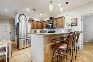 a kitchen with a counter with chairs and a refrigerator at The Village at Gruene in New Braunfels