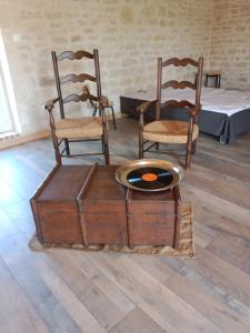 a room with chairs and a table with a bowl on a chest at Logement pleine nature in Saint-Bris-le-Vineux +19 photos