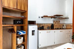 a kitchen with white cabinets and a white refrigerator at Parking, 6min to Beach & Downtown, High-Speed WiFi, Laundry Service, KingBed, PetsOK in Sayulita