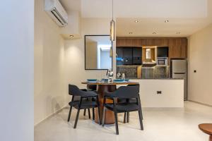 Una cocina y un comedor con mesa y sillas. en Luxury 2 BR - 1 Ensuite - POOL - By Beithady - BH-26-402, en New cairo