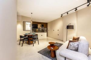 una sala de estar con un sofá y una mesa en Luxury 2 BR - 1 Ensuite - POOL - By Beithady - BH-26-402, en New cairo