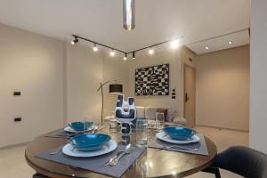 un comedor con una mesa con tazones azules en Luxury 2 BR - 1 Ensuite - POOL - By Beithady - BH-26-402, en New cairo