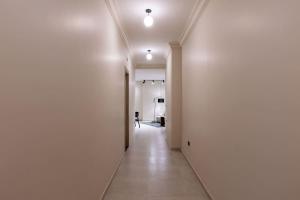un pasillo con paredes blancas y un pasillo largo con un pasillo en Luxury 2 BR - 1 Ensuite - POOL - By Beithady - BH-26-402, en New cairo 23 fotos más