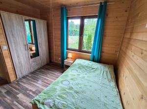 a bedroom with a bed in a wooden room at Domki Apartamenty Ewelka in Okuninka