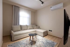 una sala de estar con un sofá y un taburete en Luxury 2 BR - 1 Ensuite- POOL - By Beithady - BH-26-102, en New cairo 33 fotos más