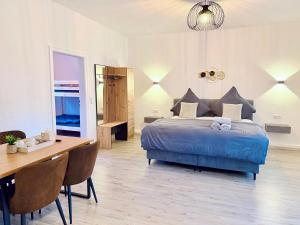 a bedroom with a bed and a table and a desk at Ferienwohnung DanVie in Varel