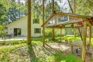 a wooden house with a picnic table and a bench at Less Than 1 Mi to ATV Trails Cadillac Golf Retreat! in Cadillac