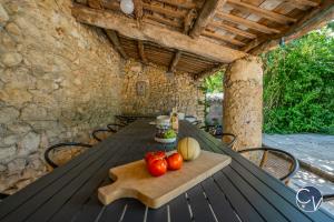 ein Holztisch mit Tomaten auf einem Holzschneidebrett in der Unterkunft Mas des Glycines in Saint-Montan