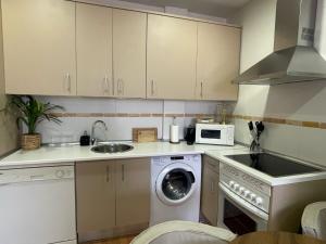 a kitchen with a washing machine and a sink at El Camino Casa Boutique in Cifuentes