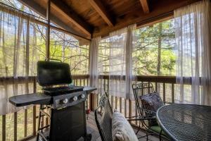 a screened in porch with a stove and a table at Anglers Bend By Avada Properties in Pigeon Forge