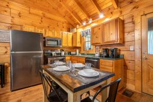 a kitchen with a table and a refrigerator at Anglers Bend By Avada Properties in Pigeon Forge