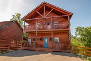 a log cabin with a balcony and a blue door at Amazing Grace By Avada Properties in Sevierville
