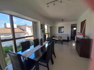 een woonkamer met een tafel en stoelen en een groot raam bij Reflejo de Mar in Villa Gesell