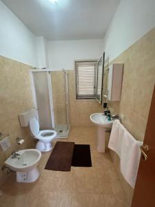 a bathroom with two sinks and a toilet and a shower at Villa acqua e sale in Santa Maria Del Focallo
