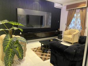 a living room with a couch and a flat screen tv at Richj luxury apartment in Benin City +11 photos