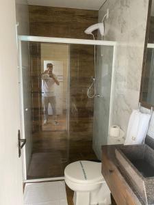 a man taking a picture of a shower in a bathroom at Residencial Luce Del Sole in Joinville +71 photos