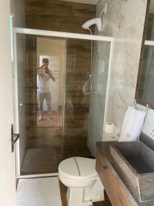 a man taking a picture of a shower in a bathroom at Residencial Luce Del Sole in Joinville