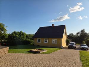 a house with a fire pit in front of it at Linnamaja kuni 10-le inimesele in Karksi-Nuia