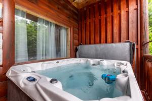 a bath tub in a room with a window at Bear Essentials Lodge By Avada Properties in Sevierville +52 photos