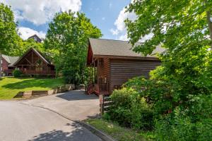 a log home with a garage and a driveway at Bear Essentials Lodge By Avada Properties in Sevierville