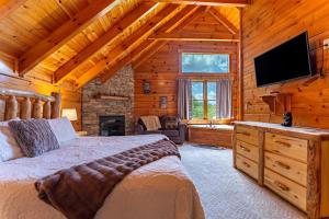 a bedroom with a bed and a television in a log cabin at Bear Essentials Lodge By Avada Properties in Sevierville