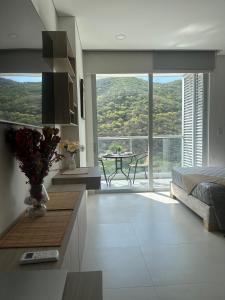 a bedroom with a bed and a table with a view at 707 Chess Loft en Pozos Colorados in Santa Marta
