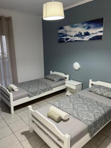 a bedroom with two beds and a blue wall at Blue Sky Apartments 3 in Hanioti