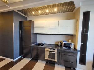 a kitchen with white cabinets and a sink and a microwave at Семейные апартаменты в Мост Сити зал и 1 спальня, вид на реку, балкон Ванна in Dnipro +16 photos