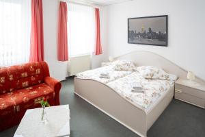 a small bedroom with a bed and a chair at Hotel Bavaria in Döbeln +18 photos