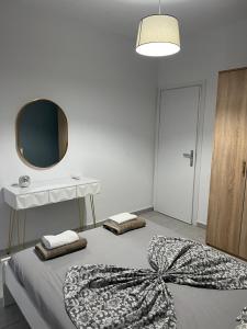 a bedroom with two beds and a table and a mirror at Blue Sky Apartments 3 in Hanioti +4 photos