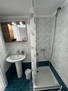 a bathroom with a sink and a shower and a toilet at Blue Sky Apartments 3 in Hanioti