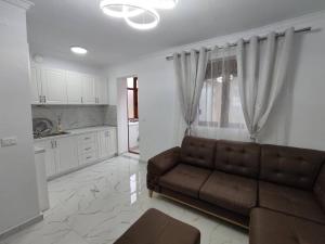 a living room with a couch and a kitchen at Korca Apartament Koci in Korçë
