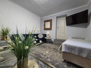 a bedroom with a bed and a table with a plant at Noclegi Gwardia in Koszalin